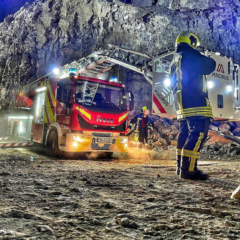 Hubrettungsgerät bei Nacht im Steinbruch. Rettungskorb ist vor dem Fahrzeug abgelegt.