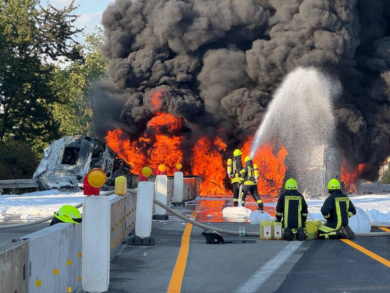 Brennender Tankzug der von Atemschutzgeräteträgern mit Schaummittel gelöscht wird.