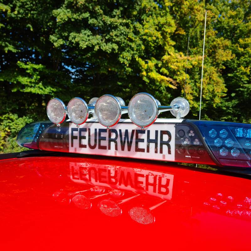 Sirenen eines roten Autodachs. Schriftzug mit Feuerwehr ist zu sehen. 