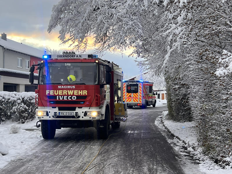 Hilfeleistungslöschfahrzeug im Winter an einer Einsatzstelle. Im Hintergrund ist befindet sich ein Rettungswagen.