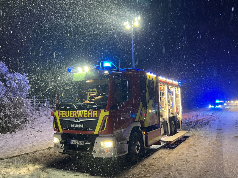 Löschgruppenfahrzeug im Schneetreiben mit ausgefahrenem Lichtmast. 
