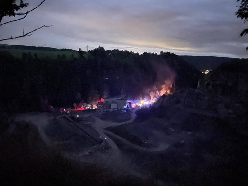 Im Dunkeln ist ein Steinbruch bei Nacht zu erkennen. Im Steinbruch brennt es und wird eine Übung durchgeführt.